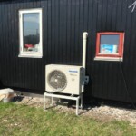 Billede af anlæg der står på jordstativ. Denne montageform anvendes ofte ved træhuse for at undgå rystelser fra varmepumpen forplanter sig i huset.