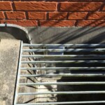 Diskret udsug fra kælderen gemt under en rist.